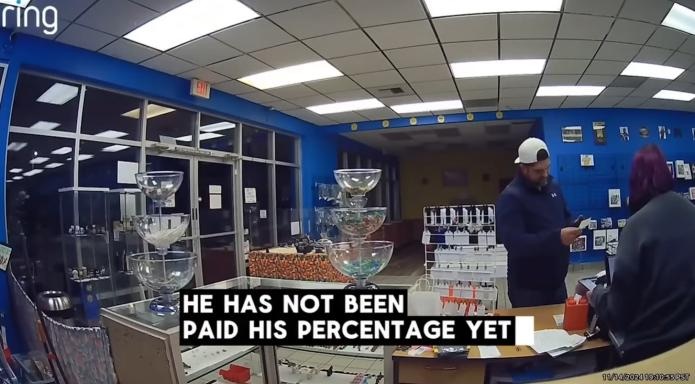 A Ring security-camera still from inside the Salem store on November 14, 2024, two people standing at the sales counter. A burned-in caption reads: HE HAS NOT BEEN PAID HIS PERCENTAGE YET.